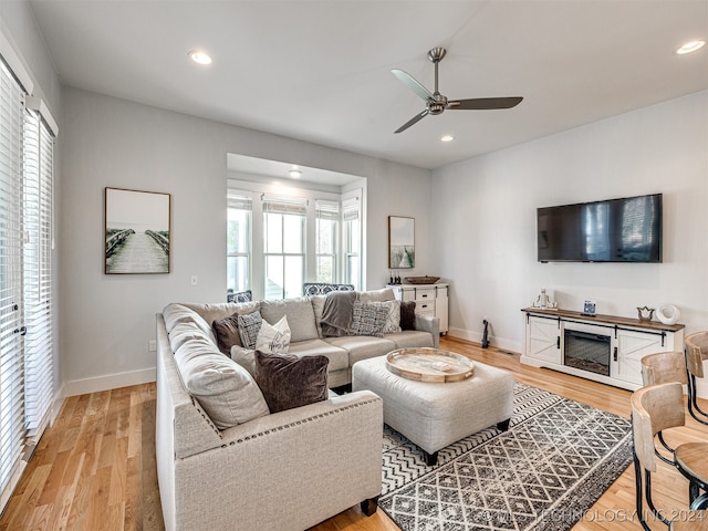 living room featuring light hardwood / wood-style flooring and ceiling fan