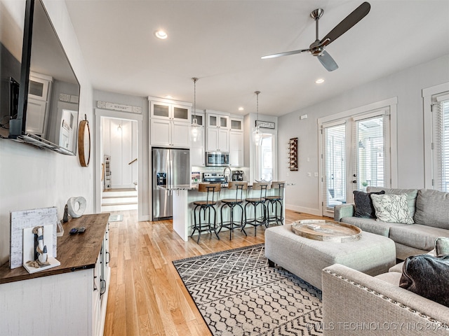 living room featuring ceiling fan and light hardwood / wood-style floors