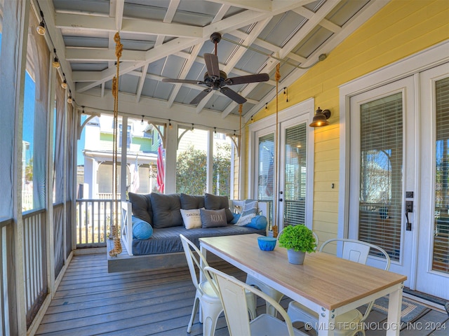 sunroom featuring lofted ceiling with beams and ceiling fan