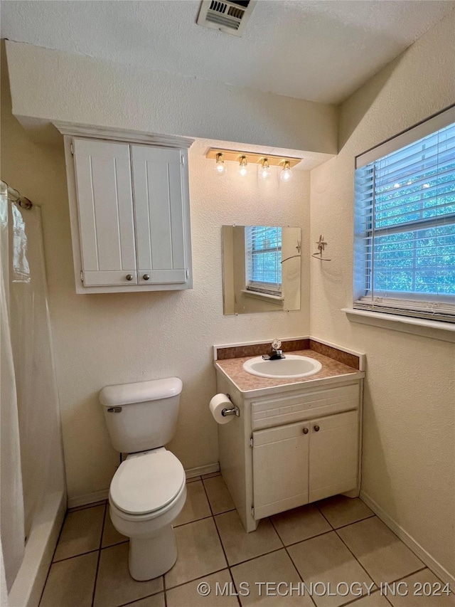 bathroom featuring toilet, vanity, and tile patterned floors