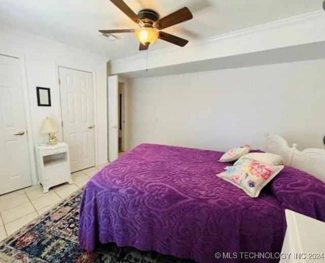 tiled bedroom with ceiling fan and crown molding