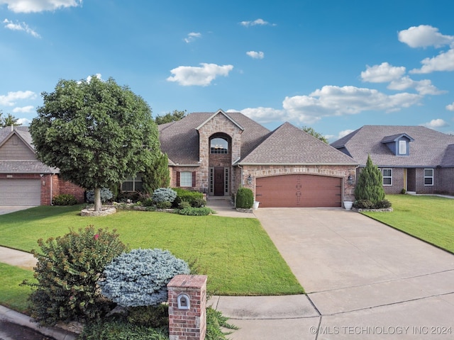 french provincial home with a garage and a front lawn