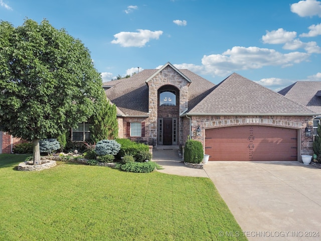 view of front of property with a garage and a front lawn