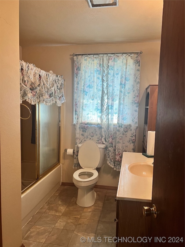 full bathroom featuring vanity, toilet, tile patterned floors, and enclosed tub / shower combo