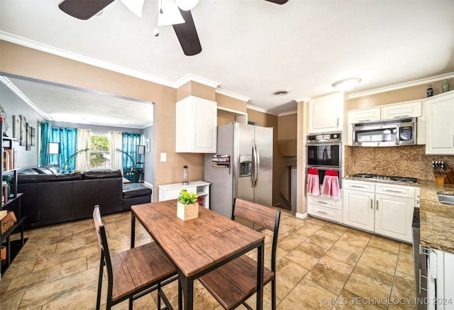 kitchen with light tile patterned floors, appliances with stainless steel finishes, tasteful backsplash, white cabinetry, and ceiling fan