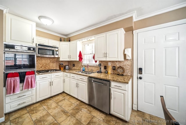 kitchen with ornamental molding, white cabinetry, sink, appliances with stainless steel finishes, and light tile patterned flooring