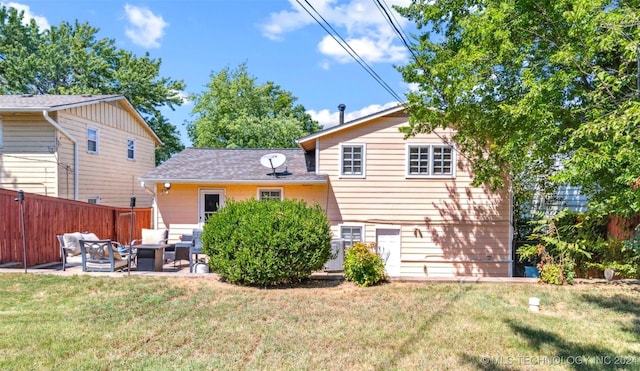 rear view of property with an outdoor living space, a patio area, and a lawn