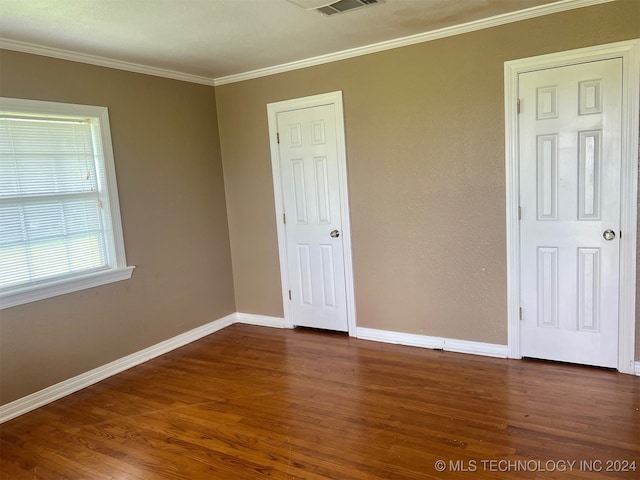 spare room with crown molding and dark hardwood / wood-style floors