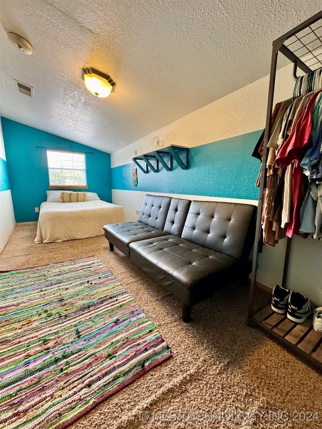 carpeted bedroom with vaulted ceiling and a textured ceiling