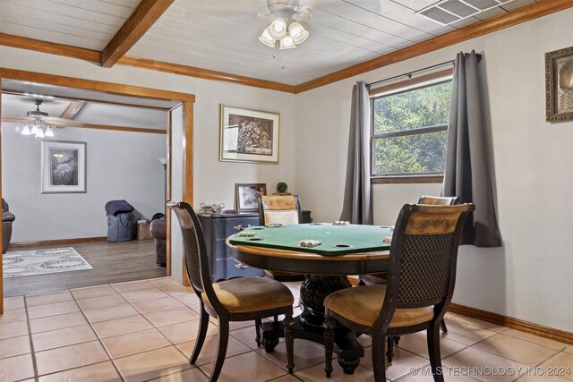 dining space with ceiling fan, ornamental molding, light tile patterned floors, and beam ceiling