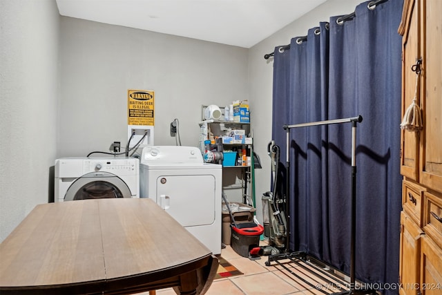 washroom featuring washing machine and dryer and light tile patterned flooring