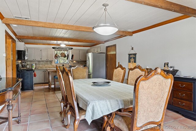 dining room with beamed ceiling and light tile patterned floors