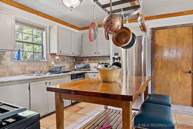 kitchen with white cabinets, backsplash, and light tile patterned floors