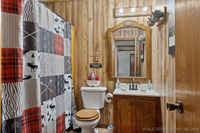 bathroom featuring wood walls, toilet, a shower with shower curtain, and vanity