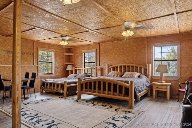 bedroom featuring multiple windows, ceiling fan, and hardwood / wood-style flooring