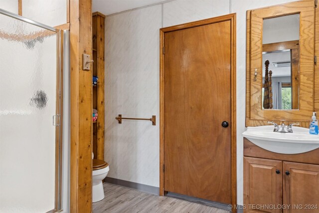 bathroom featuring tile walls, wood-type flooring, an enclosed shower, and toilet