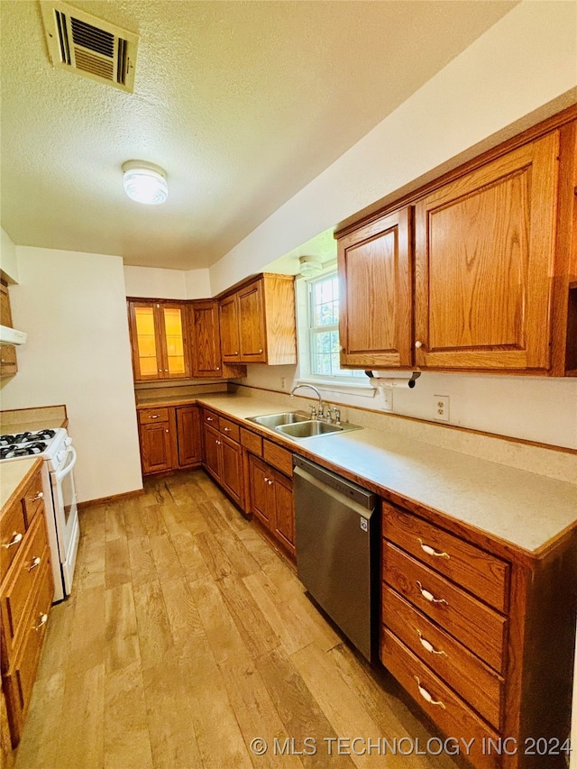 kitchen with light wood-type flooring, white gas range oven, a textured ceiling, dishwasher, and sink