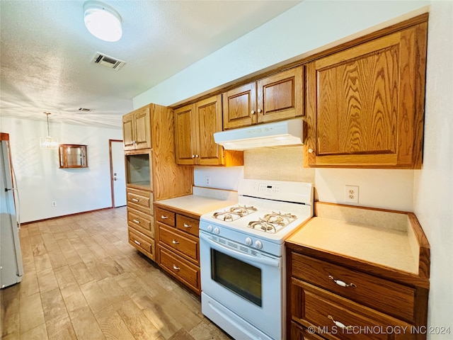 kitchen featuring white appliances, pendant lighting, a textured ceiling, and light hardwood / wood-style flooring