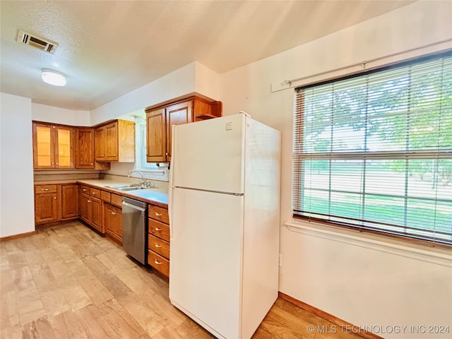 kitchen featuring dishwasher, white refrigerator, light hardwood / wood-style flooring, and sink