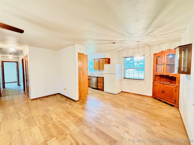 unfurnished living room with a textured ceiling, light hardwood / wood-style flooring, and a chandelier