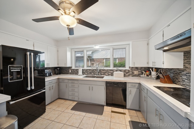 kitchen featuring tasteful backsplash, sink, gray cabinetry, light tile patterned floors, and black appliances