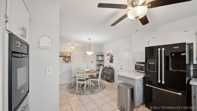 kitchen featuring pendant lighting, light tile patterned floors, ceiling fan, white cabinetry, and black appliances