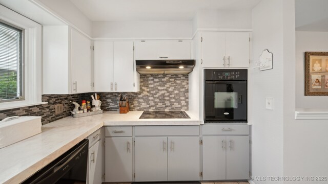 kitchen featuring backsplash, white cabinets, and black appliances