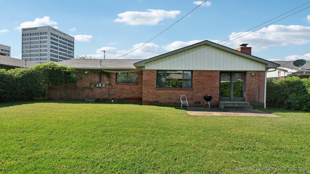 rear view of house featuring a lawn and a patio