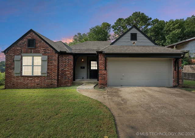 view of front of home with a yard and a garage