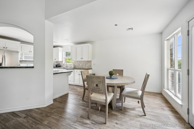 dining space with wood-type flooring and a healthy amount of sunlight