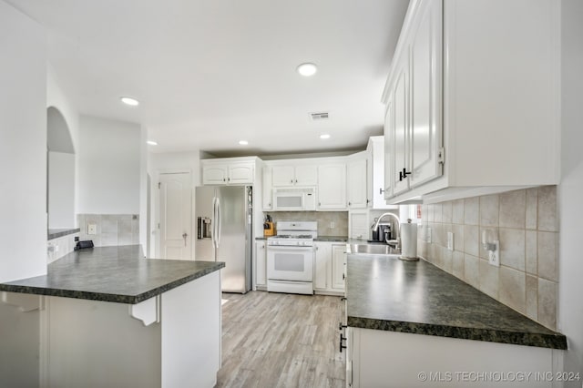 kitchen featuring white cabinetry, white appliances, kitchen peninsula, light hardwood / wood-style flooring, and sink