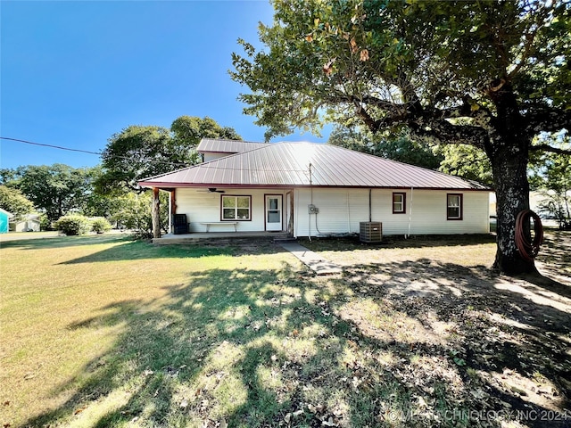 view of front facade with a front lawn, covered porch, and central AC