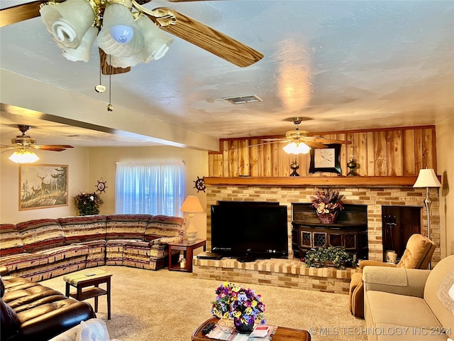 carpeted living room with ceiling fan and a fireplace