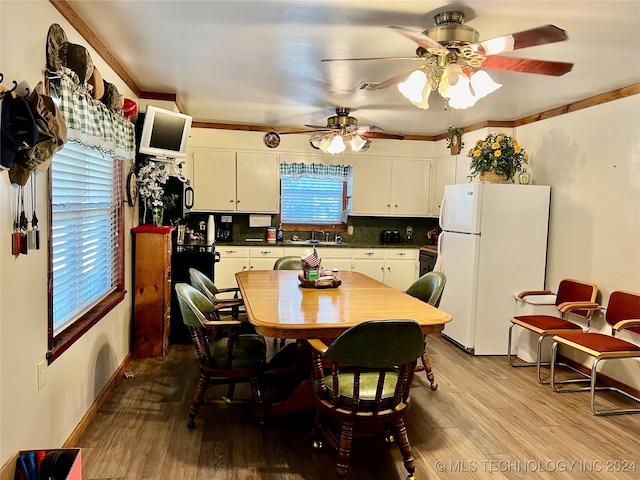 dining space featuring crown molding, hardwood / wood-style floors, sink, and ceiling fan