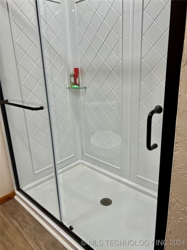 bathroom with hardwood / wood-style floors and a shower with door