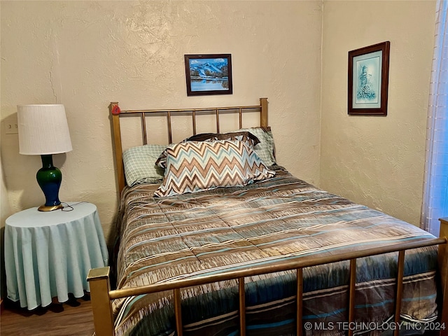 bedroom with dark wood-type flooring