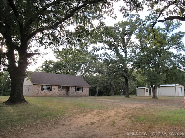 view of front of property with a storage shed and a front lawn