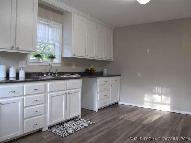 kitchen featuring dark wood-type flooring, sink, and white cabinets