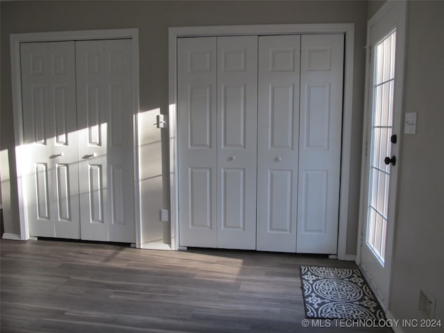 unfurnished bedroom with dark wood-type flooring and two closets