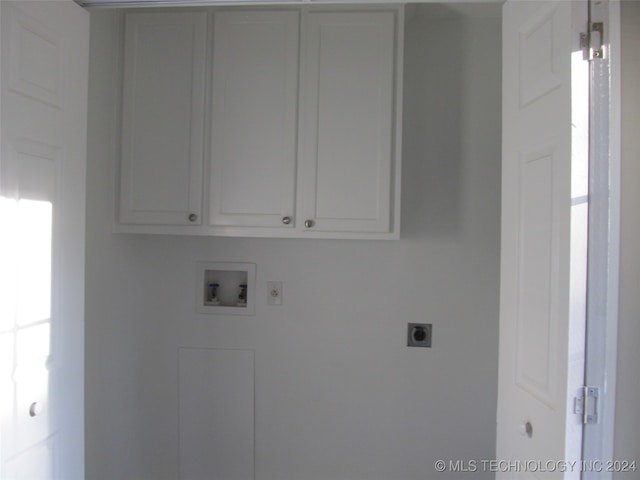 washroom featuring hookup for a washing machine, hookup for an electric dryer, and cabinets