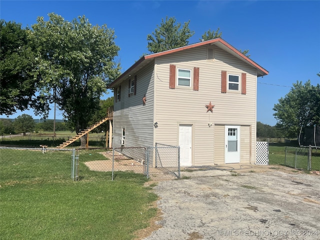 rear view of property featuring a lawn