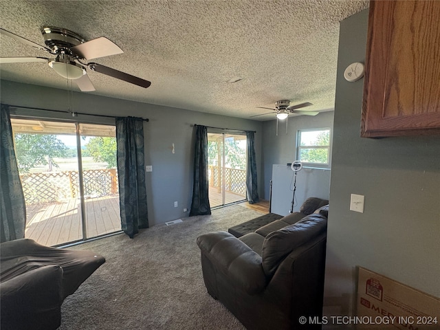 carpeted living room with ceiling fan and a textured ceiling