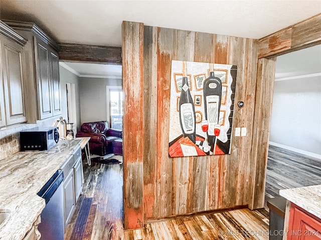 kitchen featuring wooden walls, crown molding, light stone countertops, dark wood-type flooring, and stainless steel dishwasher