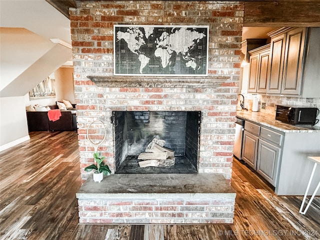 interior details featuring a fireplace, hardwood / wood-style flooring, sink, and dishwasher