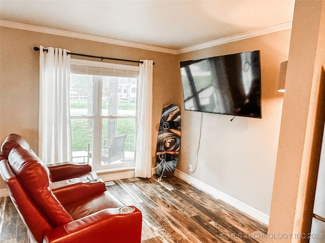 living area with crown molding and hardwood / wood-style floors