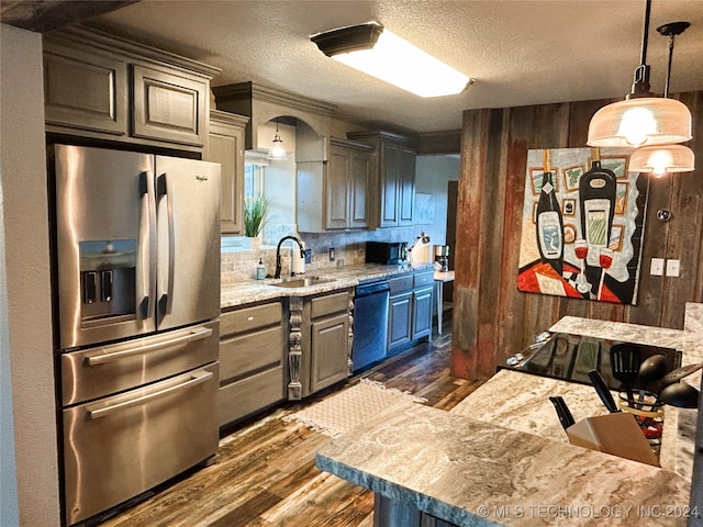 kitchen featuring tasteful backsplash, stainless steel appliances, dark hardwood / wood-style flooring, sink, and hanging light fixtures