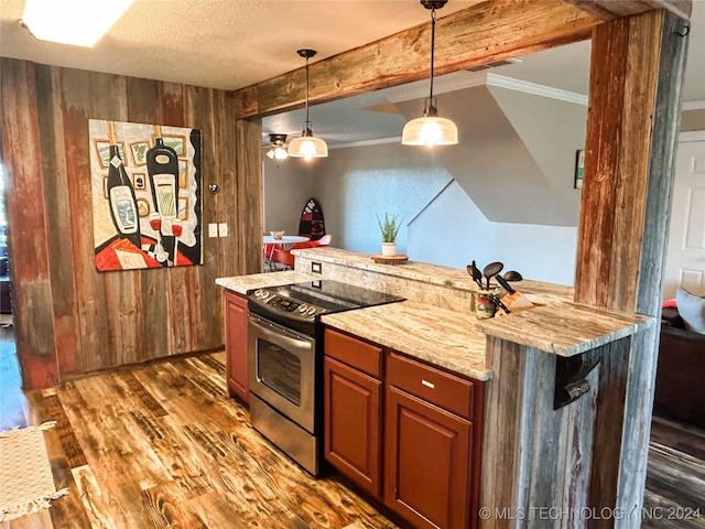 kitchen featuring a textured ceiling, decorative light fixtures, dark wood-type flooring, wooden walls, and stainless steel range with electric cooktop