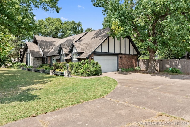 tudor house featuring a garage and a front yard