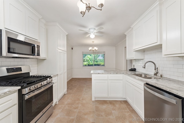 kitchen with stainless steel appliances, white cabinets, decorative backsplash, hanging light fixtures, and sink