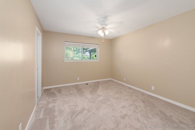 unfurnished room with light colored carpet and ceiling fan